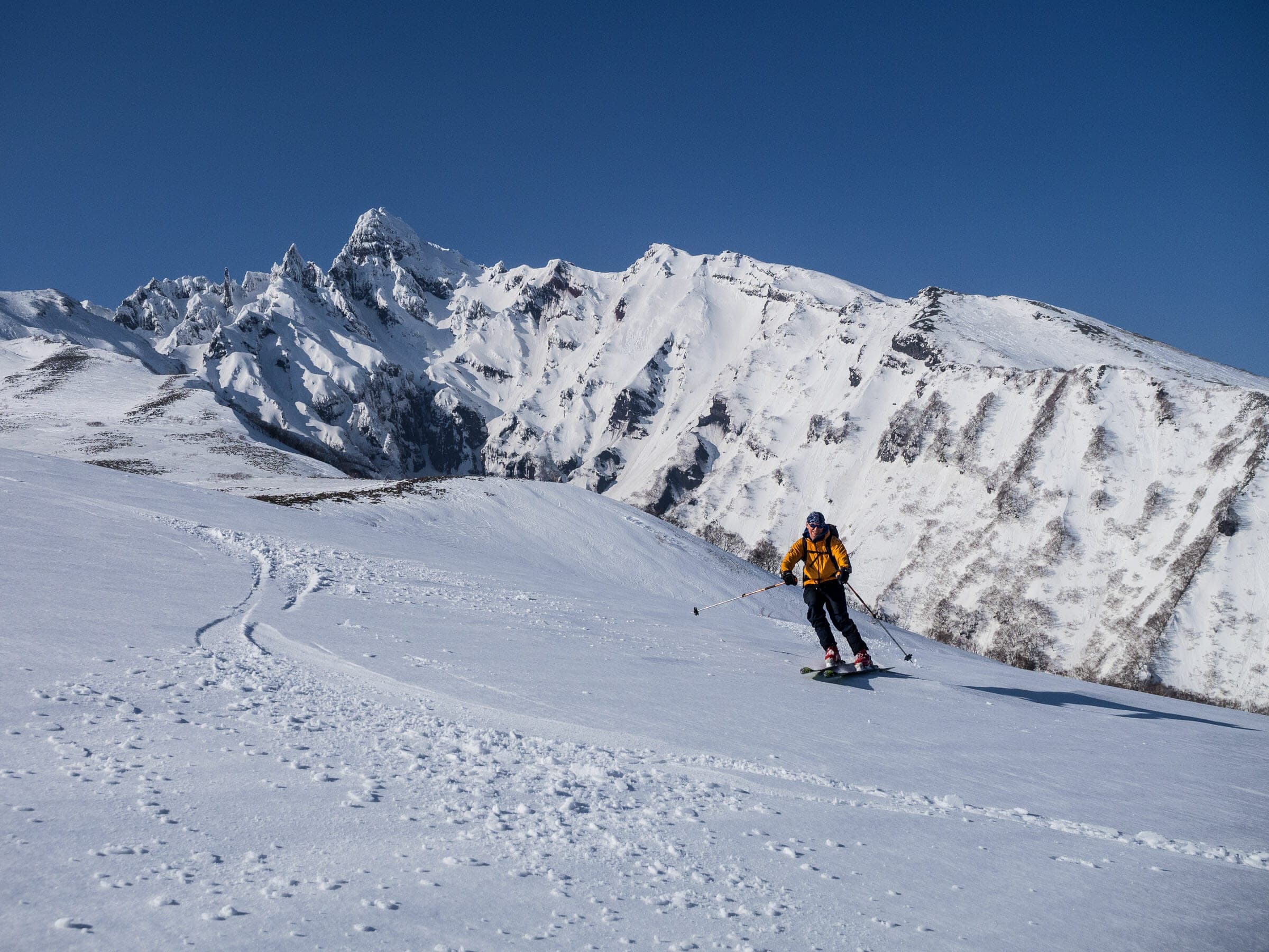 A skier turns below the rocky spires of Rishiri-zan on the Yamunai-zawa south ridge route