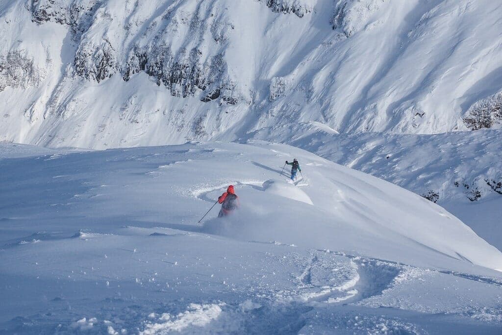 Skiers descend the steep upper slopes of Sandan-yama in the Tokachi Range