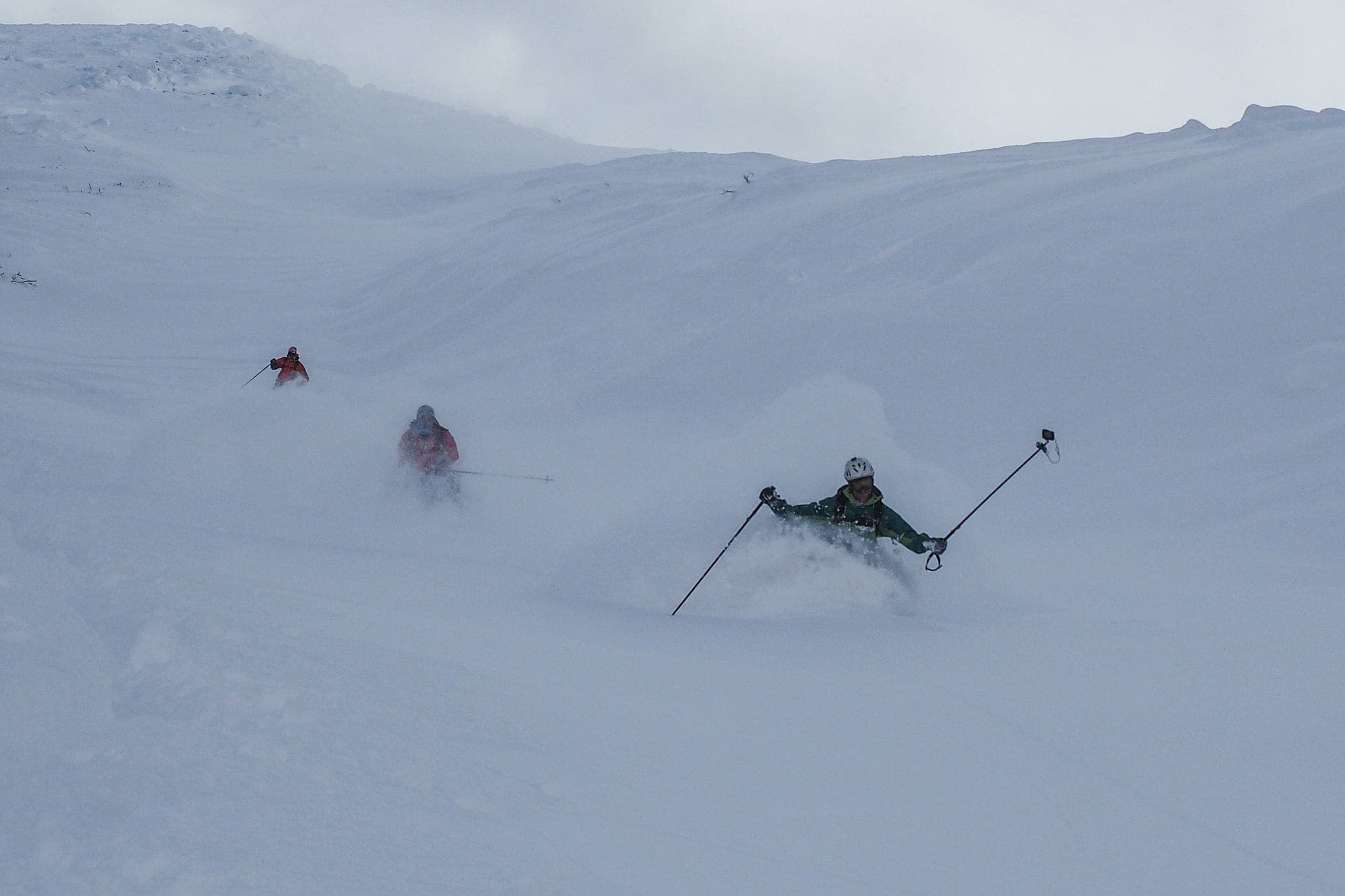Skiers descend snowfields on the Kabawara Ridge of Maetokachi-dake