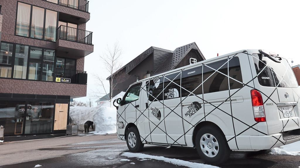 A Toyota Hiace van parked on a snowy street in Niseko