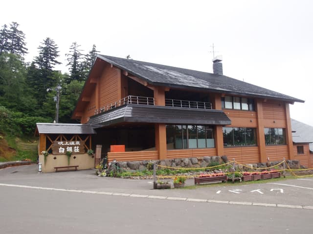 Hakuginso's timber lodge building at Fukiage Onsen in Kamifurano on a summer day