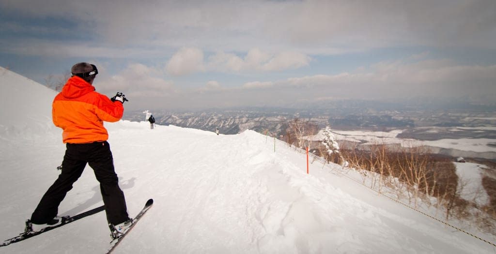 A skier looks out over the Tokachi plain from the top of Bear Mountain at Sahoro