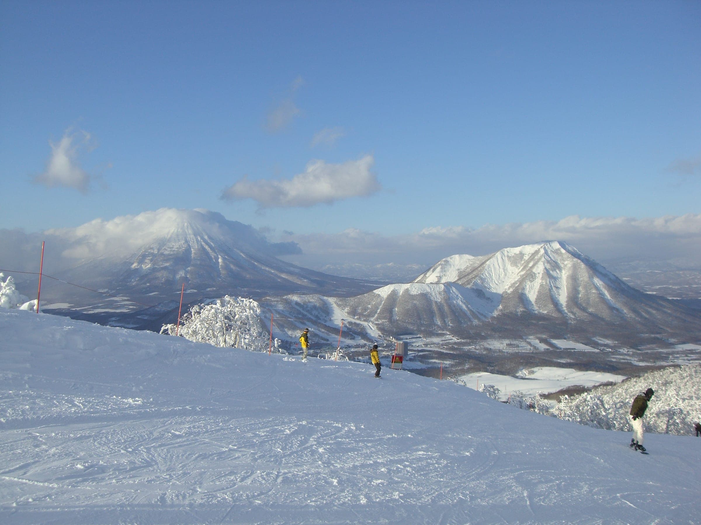 Skiers at Rusutsu look across the snow to Shiribetsu-dake and Mt. Yotei