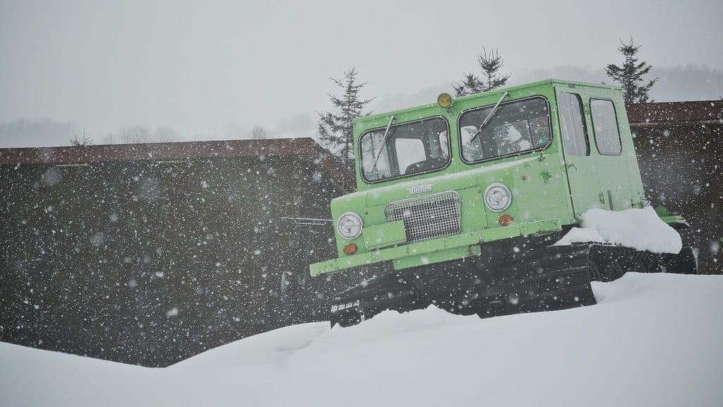 An old snowcat stands in falling snow at Niseko