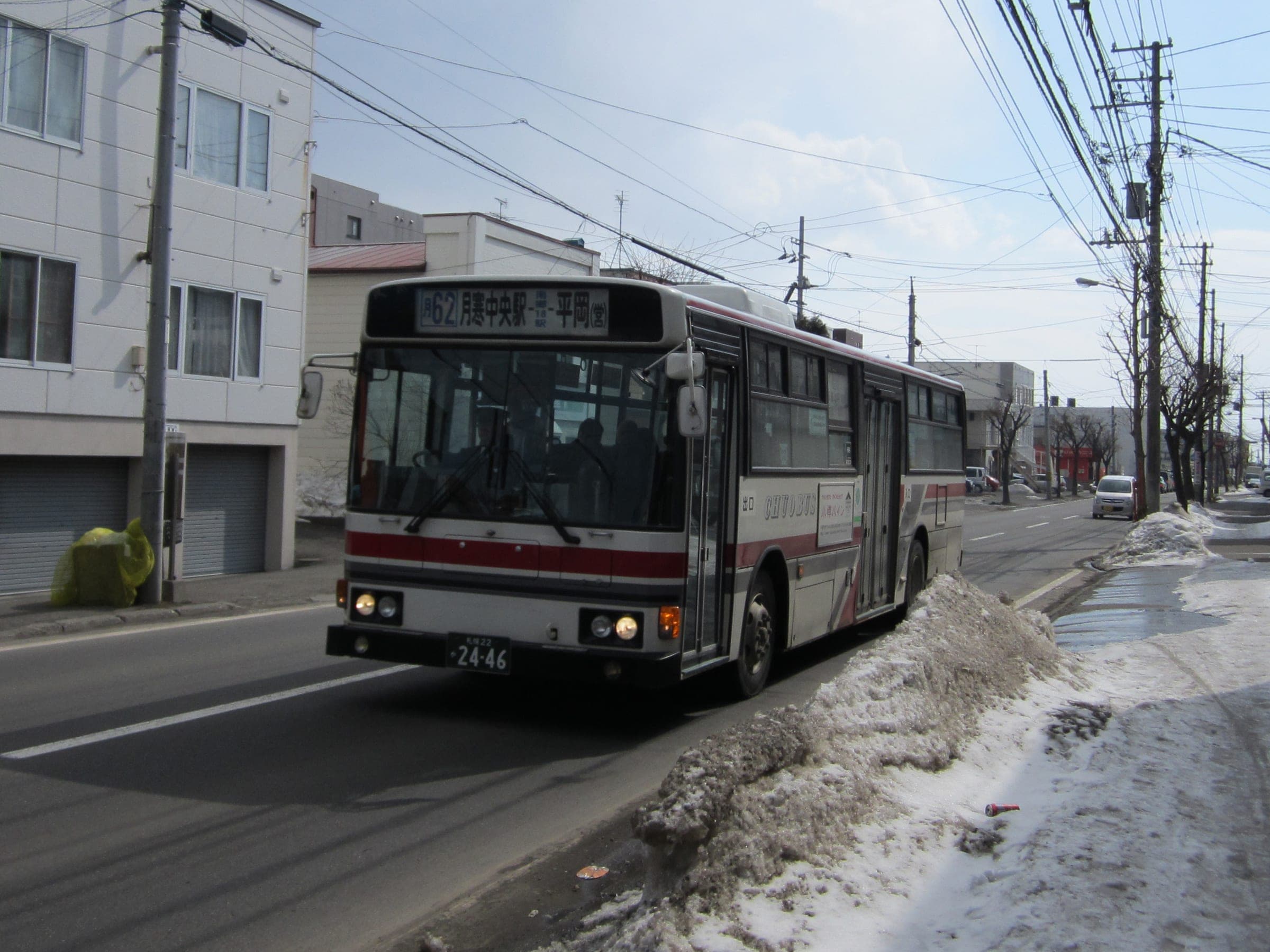 A Hokkaido Chuo Bus city bus runs down a slushy Sapporo street in winter