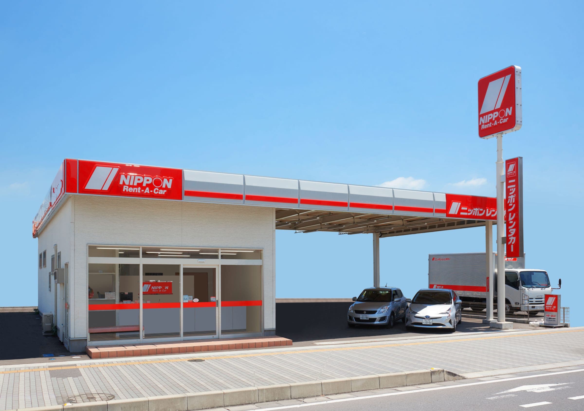 A Nippon Rent-A-Car branch with its red and white sign and rental cars out front