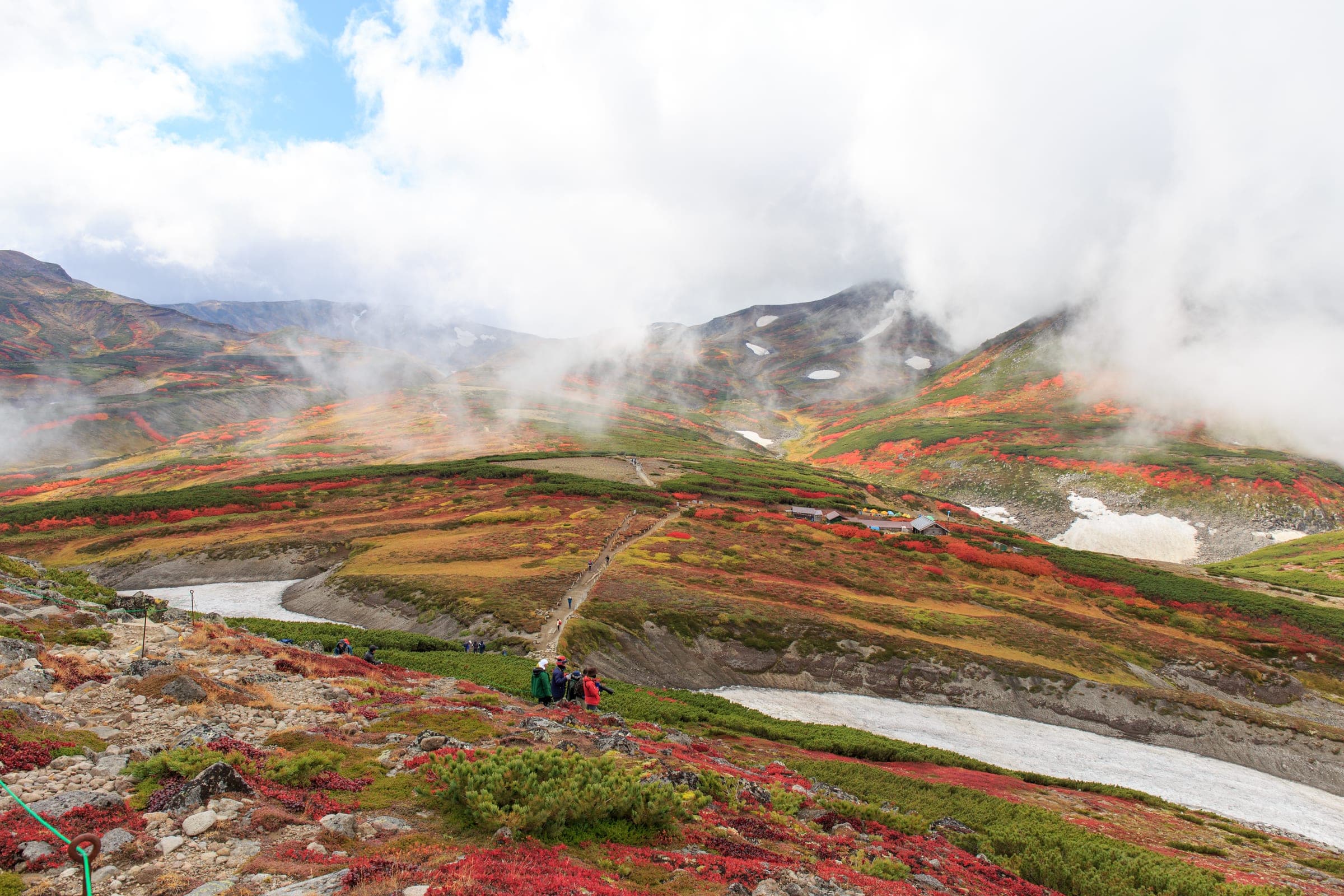 Red and orange leaves surround the Kurodake Ishimuro hut high on Mt. Kuro