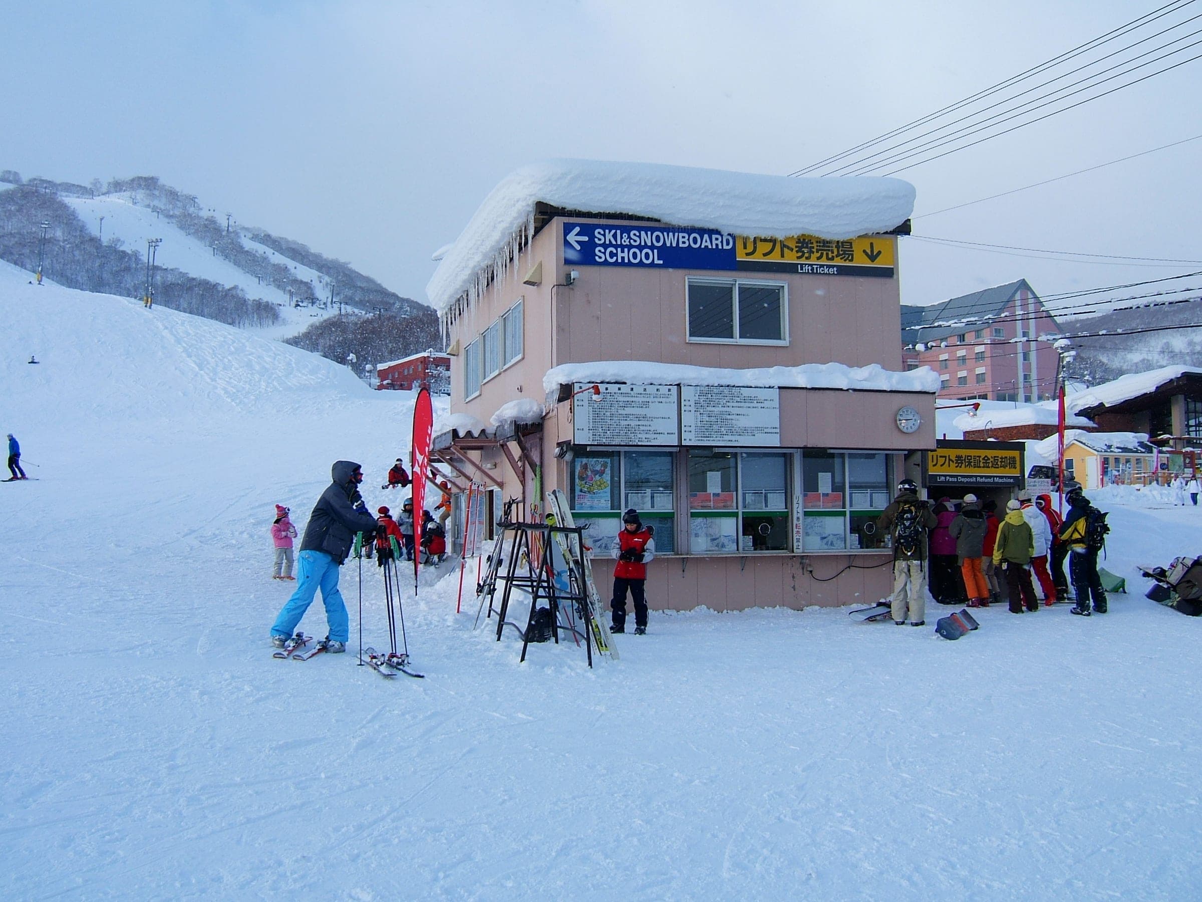 Skiers gather outside the Grand Hirafu lift ticket office at the foot of the slopes