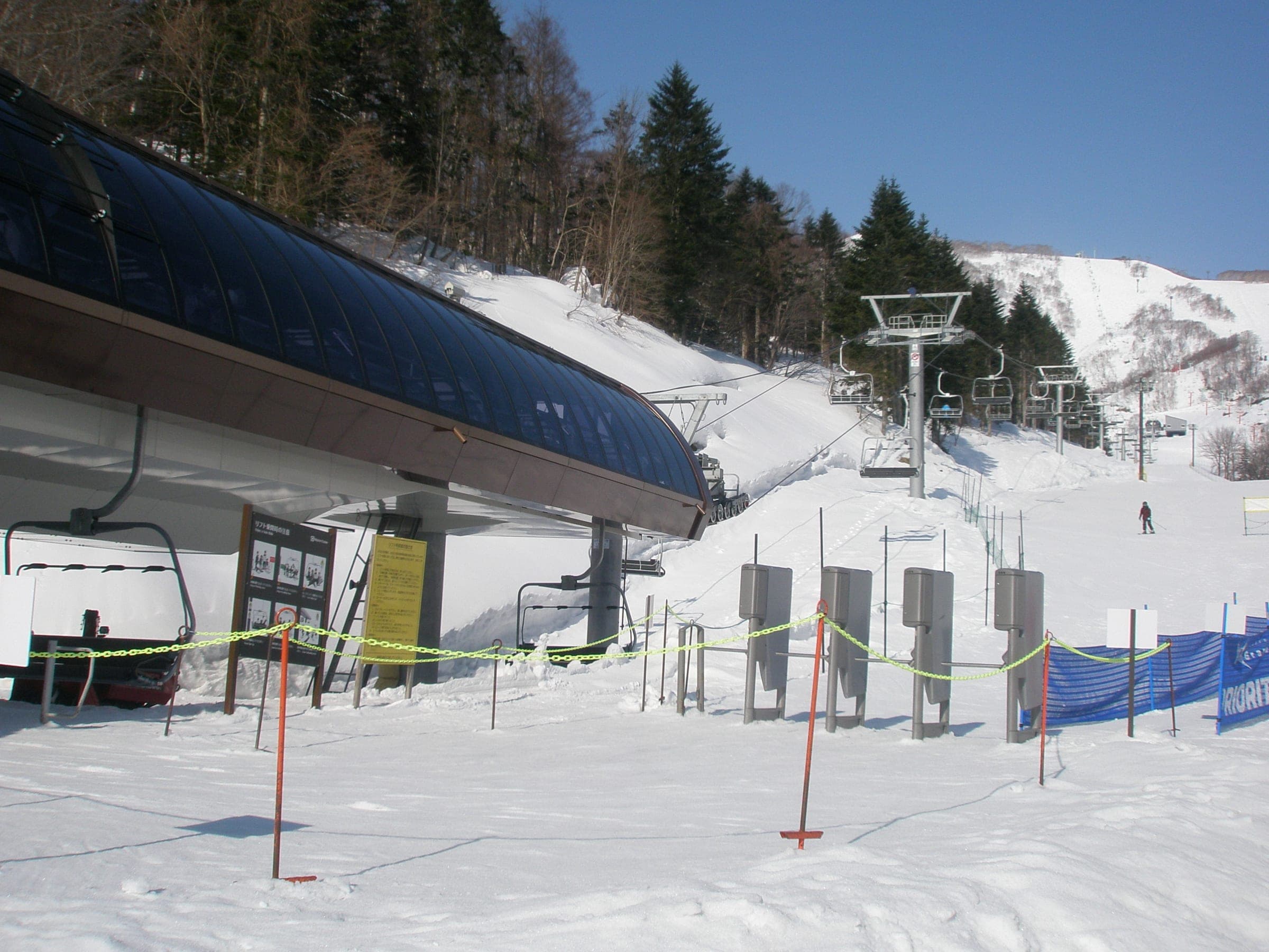 Chairs of the Ace Family Quad swing out of the loading station at Grand Hirafu