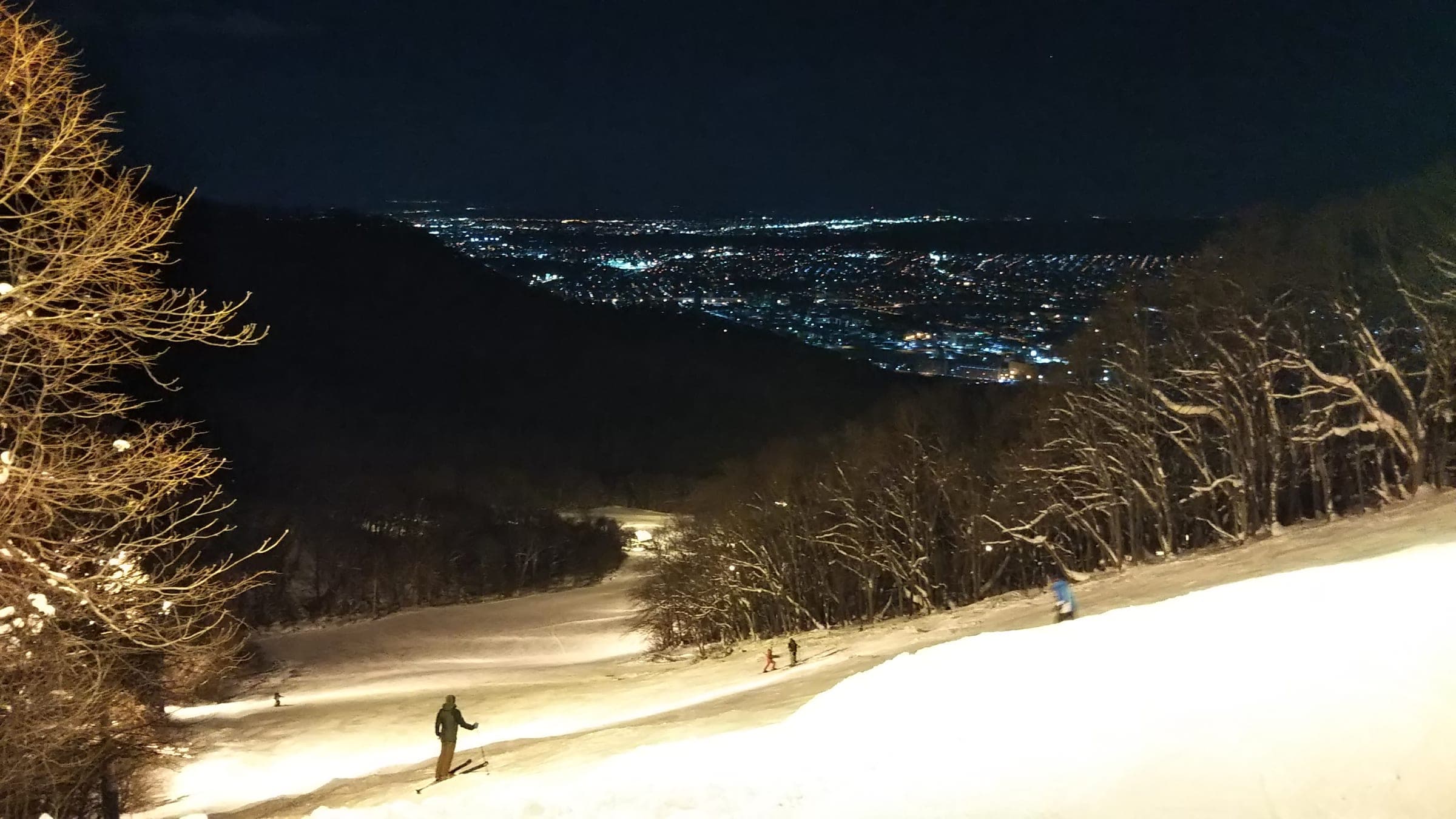 Night lights glow on the Crystal course at Sapporo Moiwayama with the city spread out below