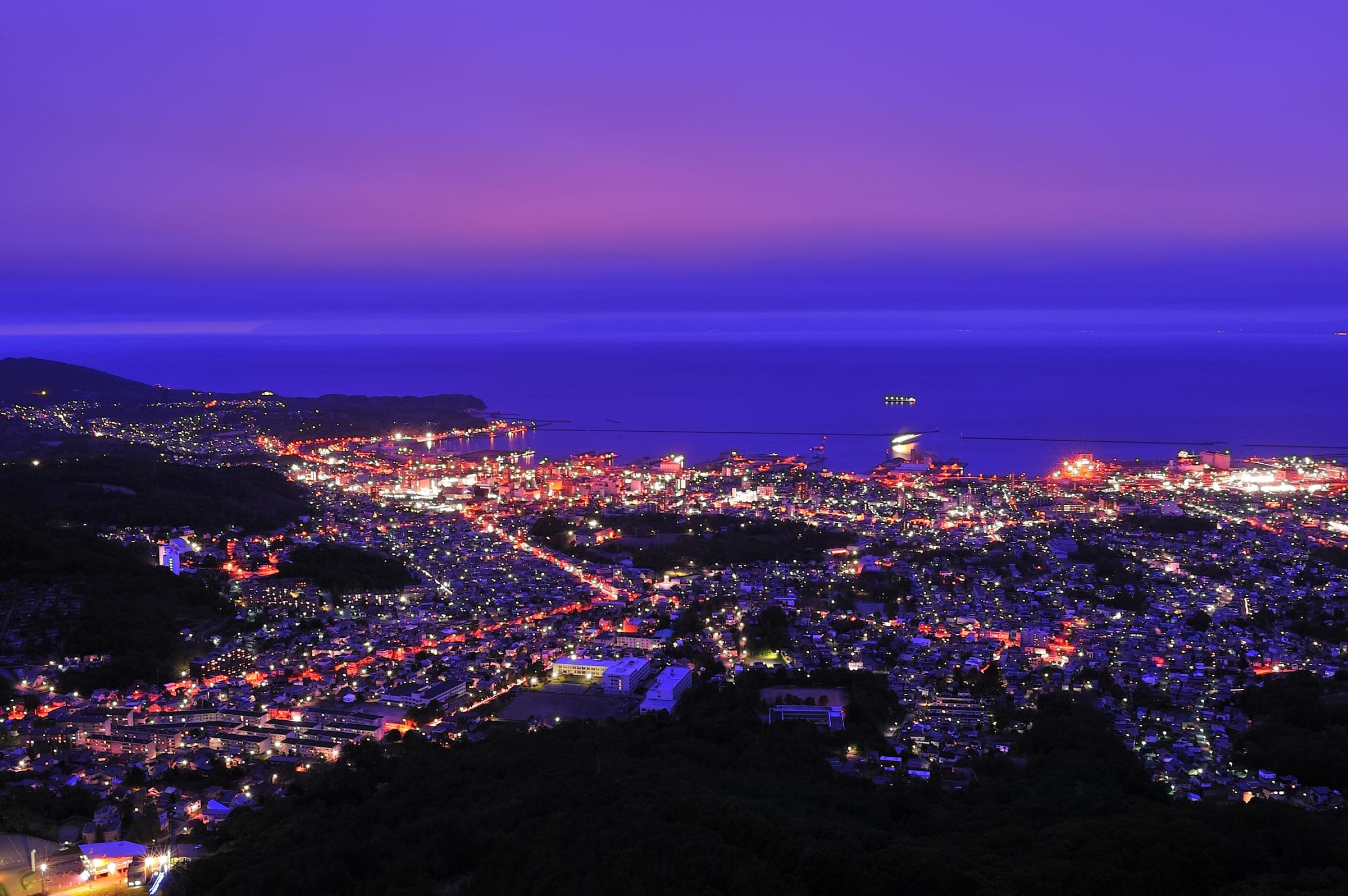 Otaru's lights spread along the bay below Tenguyama at dusk