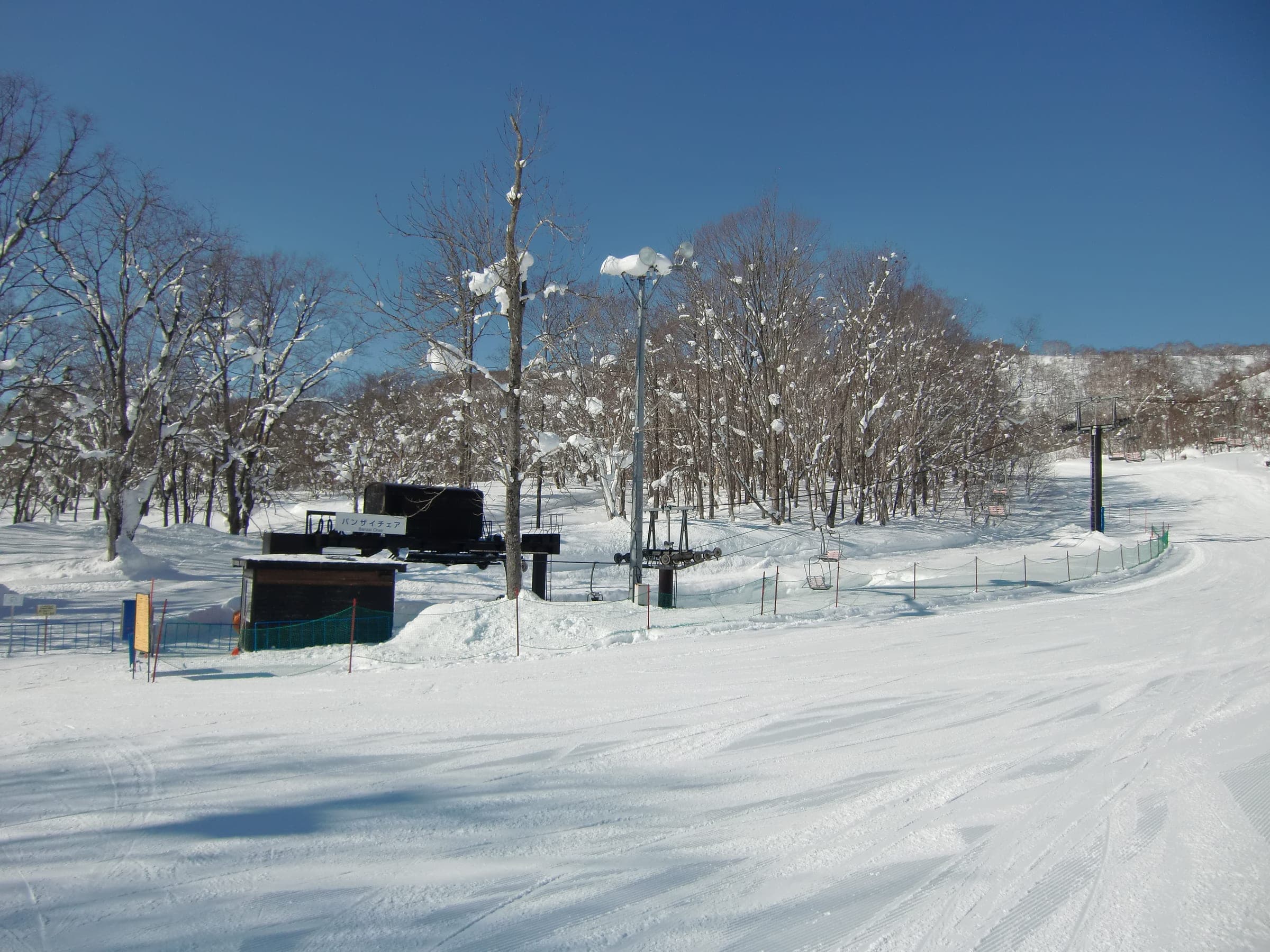 The Banzai Chair loads beside snowy birch at Niseko Village, eight minutes on foot from Freeride Lodge