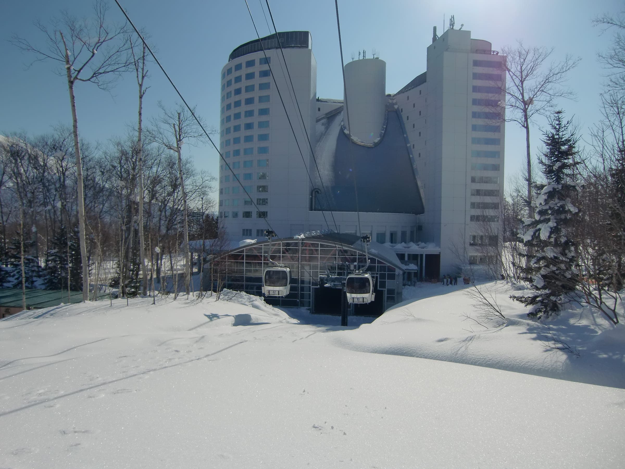 The Niseko Gondola base station and the Hilton tower stand in deep snow at Niseko Village