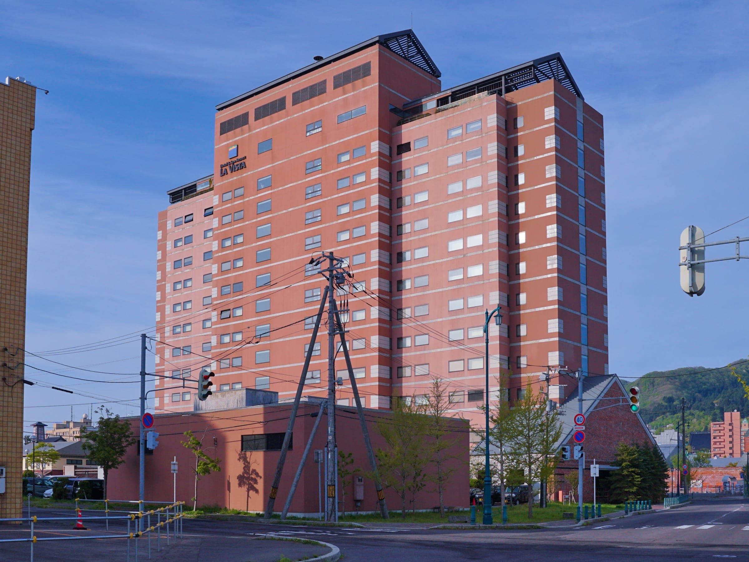 La Vista Hakodate Bay's red brick tower against a blue sky in Hakodate