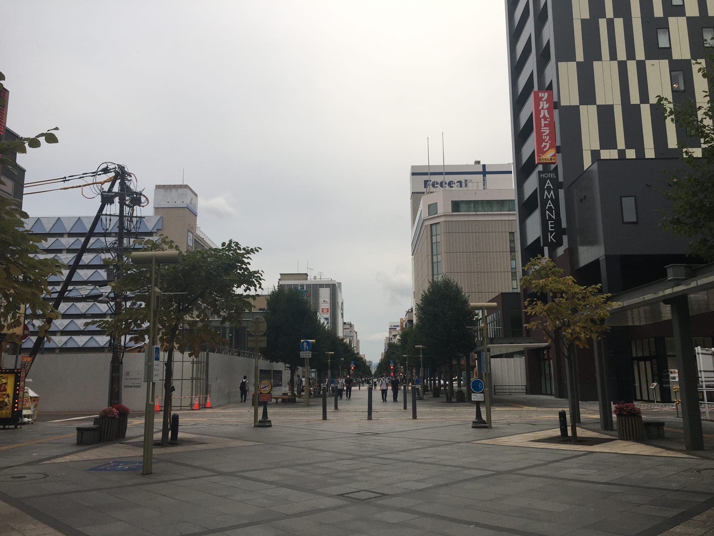The wide shopping street leading away from Asahikawa Station on a cloudy day