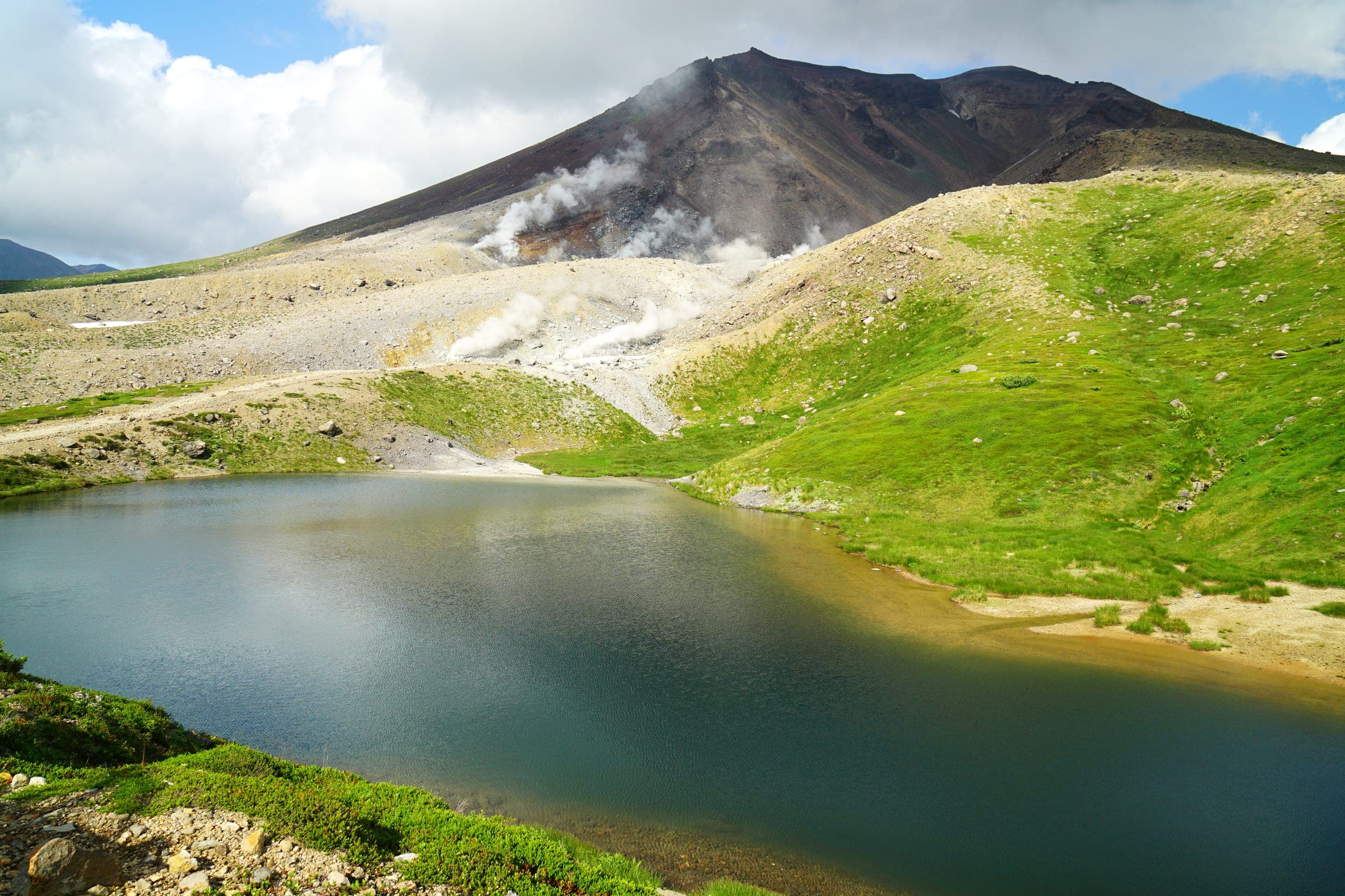Steam rises from Asahidake above Sugatami Pond in Higashikawa in summer