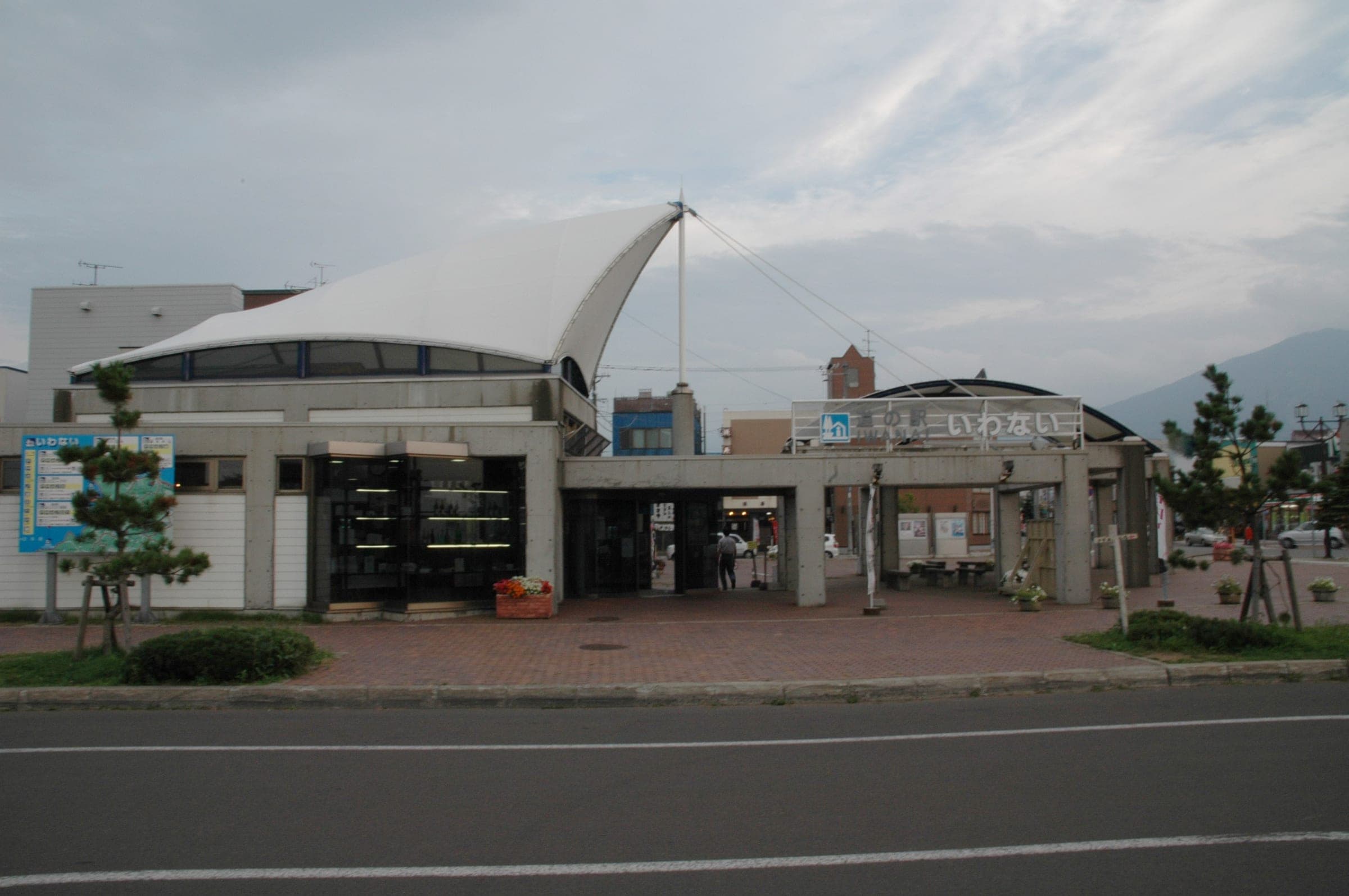 The white sail roof of Michi-no-Eki Iwanai beside the road
