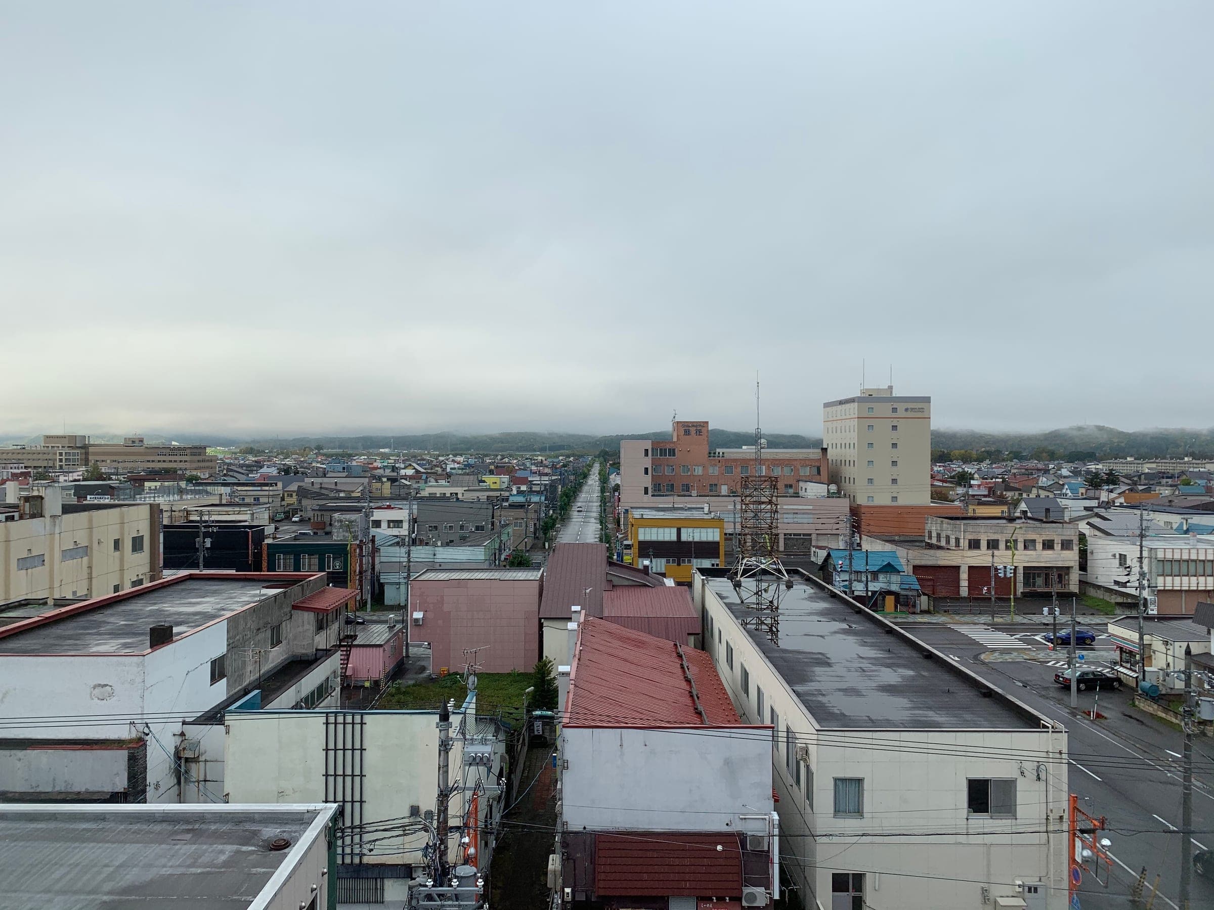 Low rooftops of central Nayoro stretch toward the hills on an overcast morning