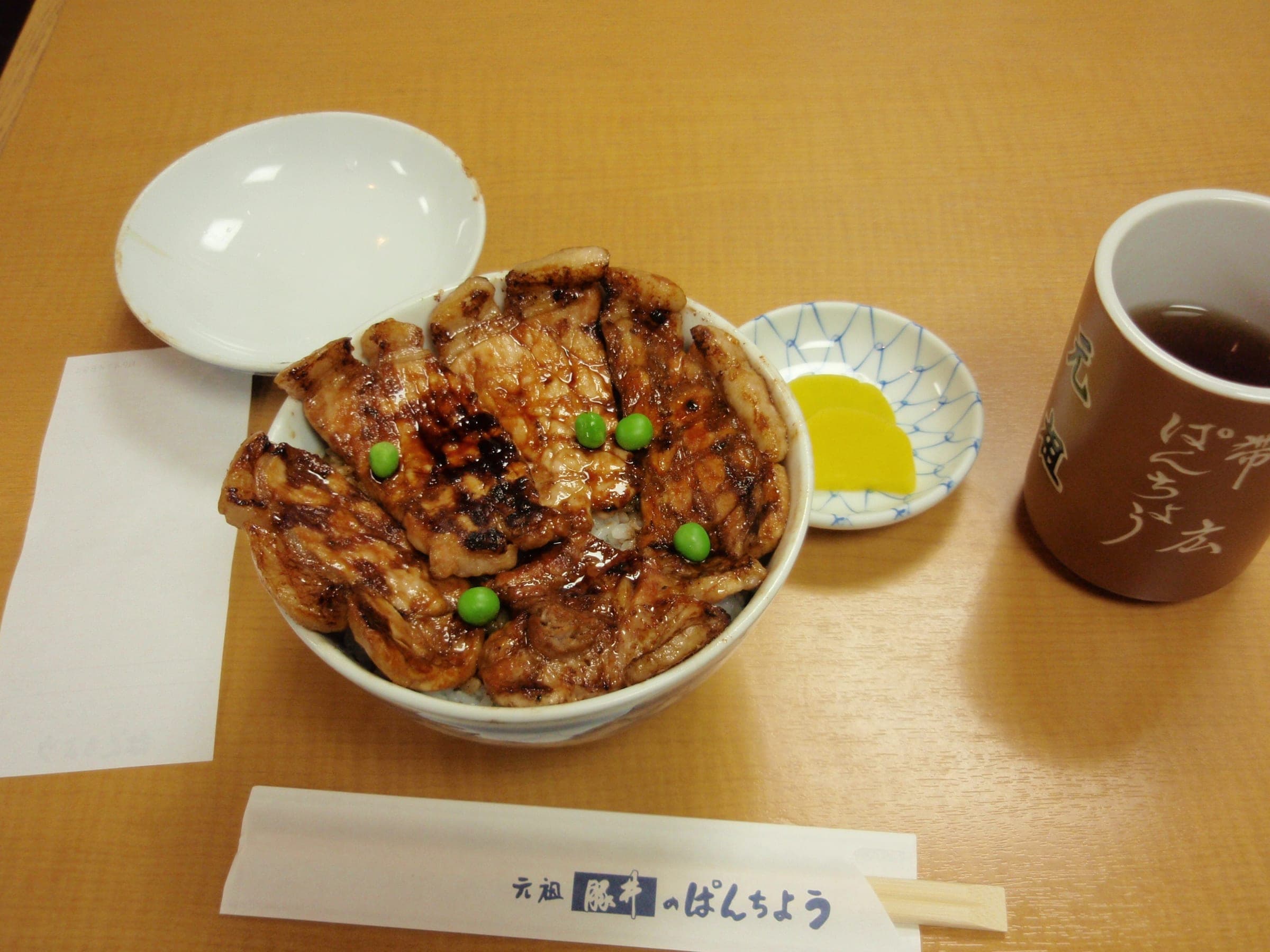 A butadon of grilled pork over rice with pickles and tea at Pancho