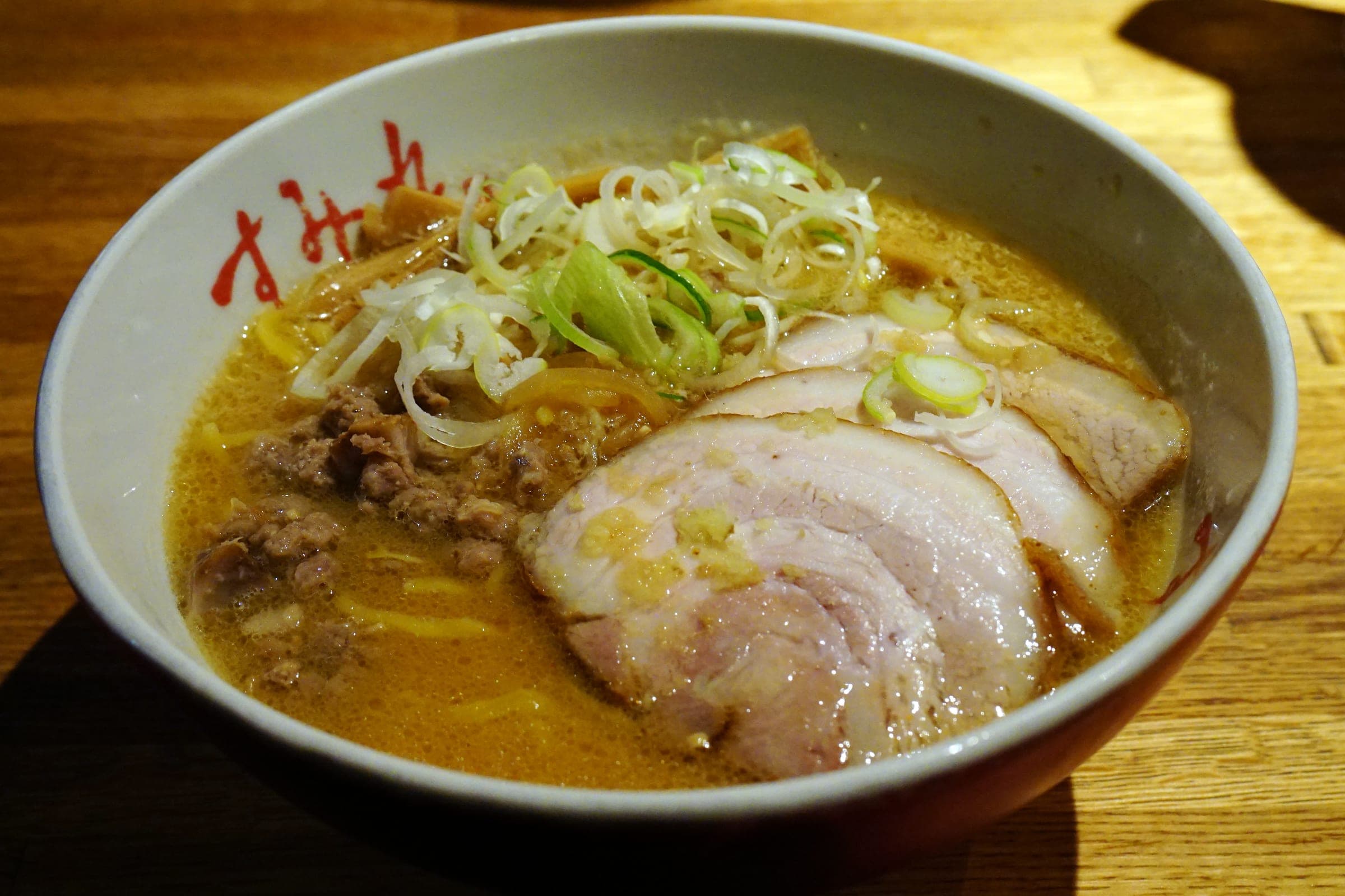 A bowl of Sumire miso ramen topped with chashu and spring onion in Sapporo