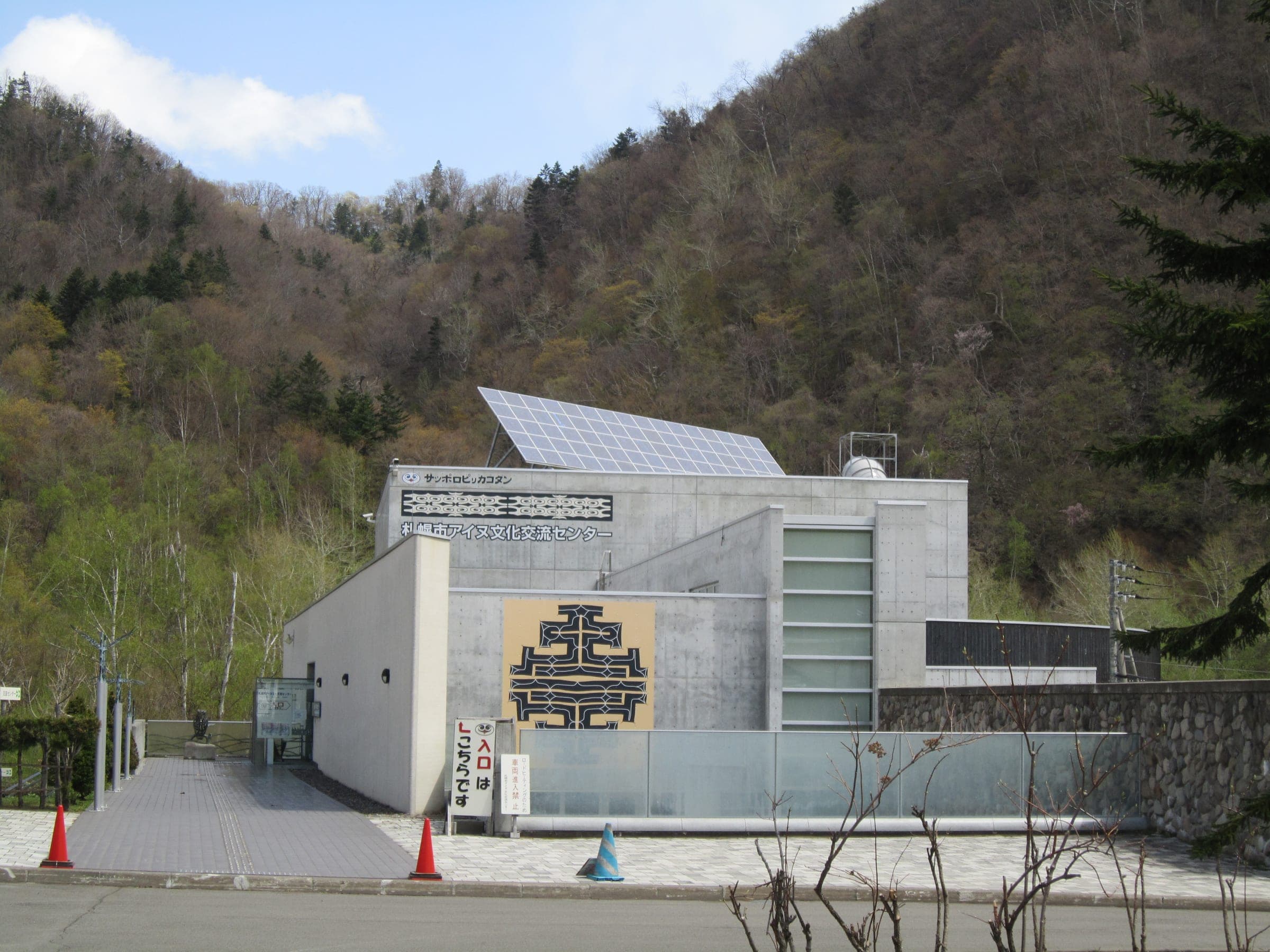 Sapporo Pirka Kotan, the Ainu culture centre, below wooded hills in Koganeyu