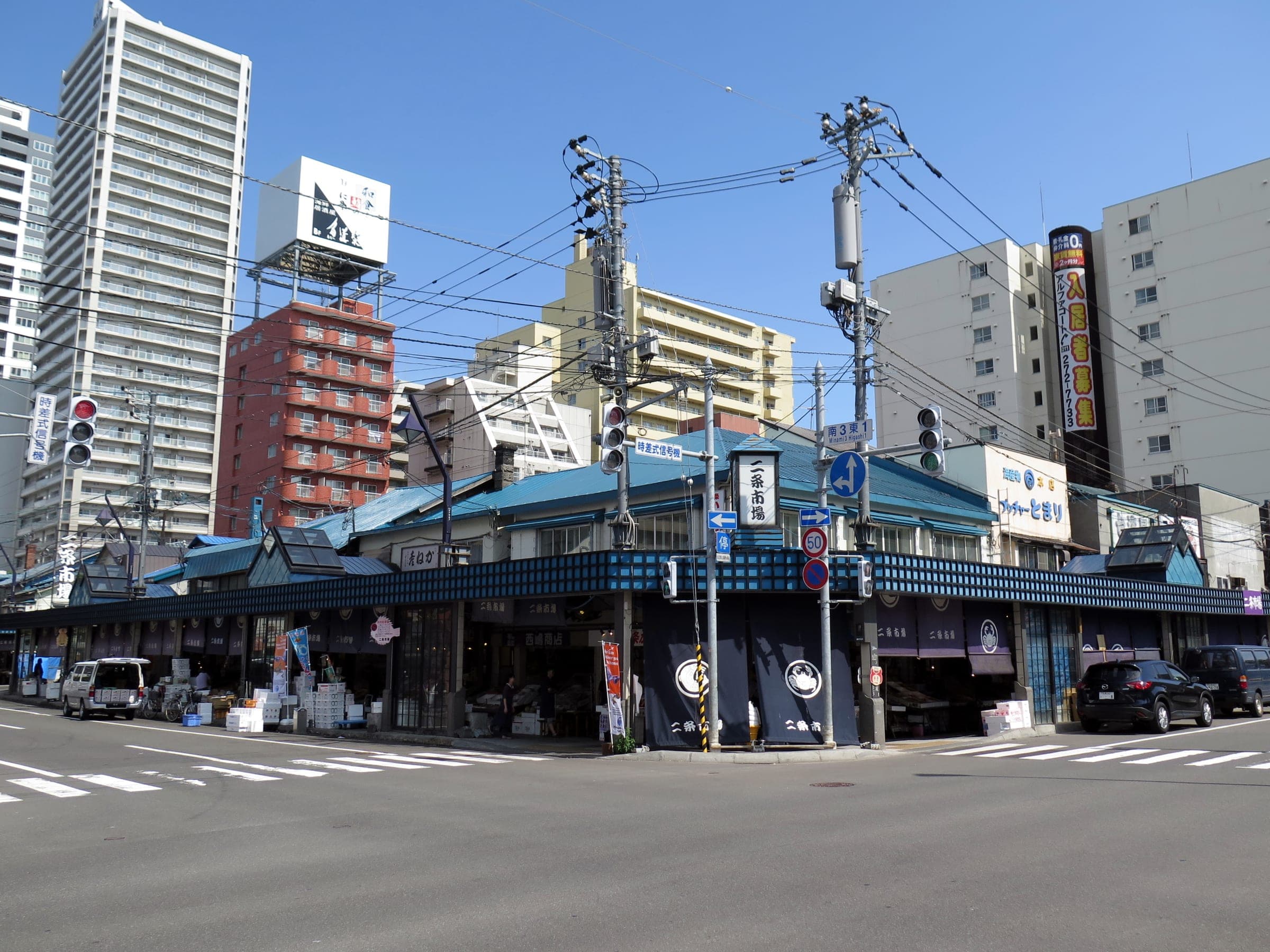 The low blue-roofed shops of Nijo Market on a Sapporo street corner