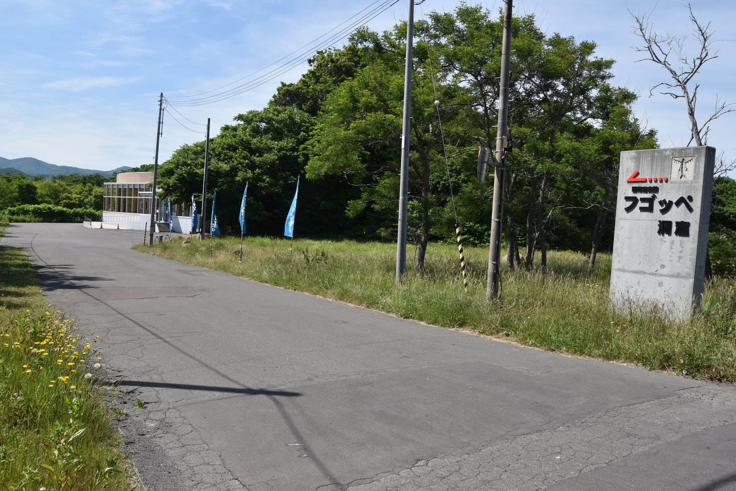 A road leads to the low Fugoppe Cave exhibit building near Yoichi